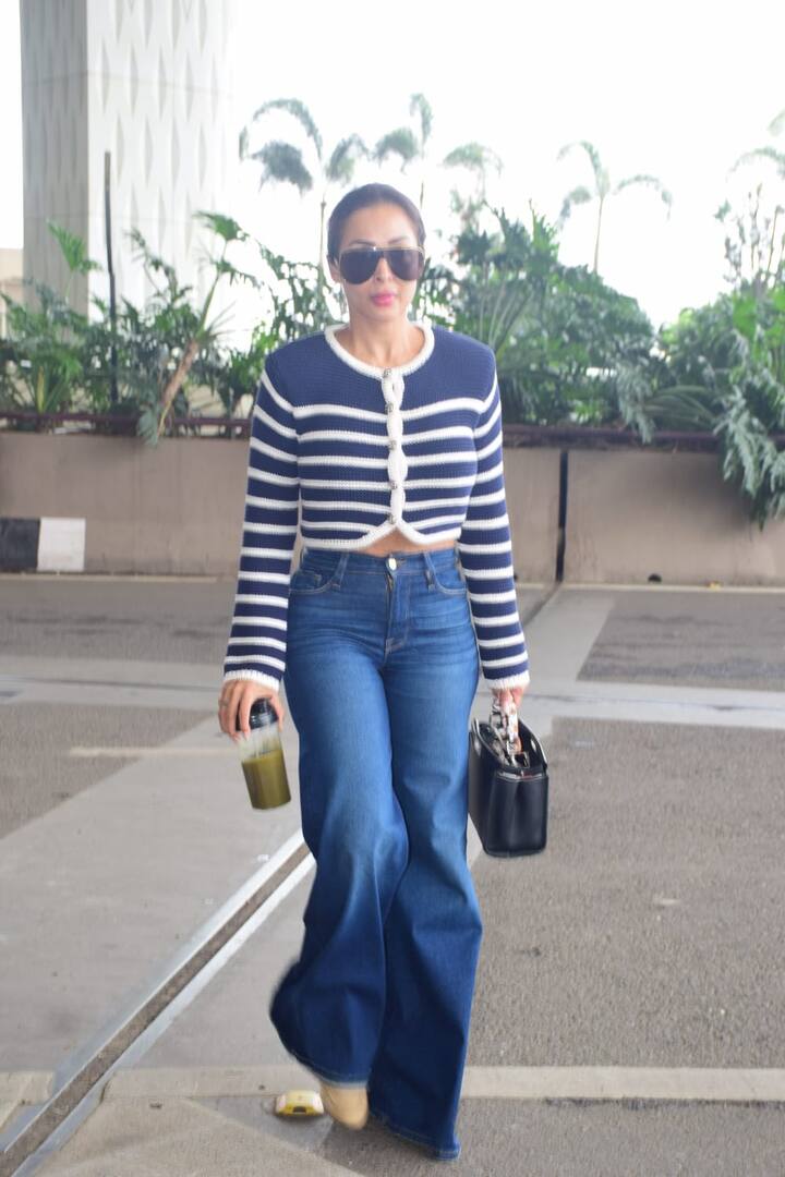 Malaika carried denim with blue and white crop tops. In which the actress was seen ploning her perfect figure.