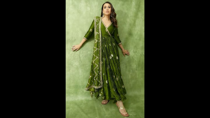 6. Karisma Kapoor: Karisma Kapoor wore a mehndi green anarkali suit set that made her look stunning. The loor-length ensemble, adorned with intricate gota patti and mirror work, balanced traditional charm and festive elegance. fitted three-quarter sleeves and V-neckline added structure, while the flared silhouette gave her a graceful, regal presence. The tonal dupatta with zigzag embellishments and playful tassels tied the look together beautifully. Whether you're attending a Teej puja, swing celebration, or a family gathering, this outfit delivers timeless style with a vibrant festive twist. (Image Source: Pinterest/perniaspopupshop)