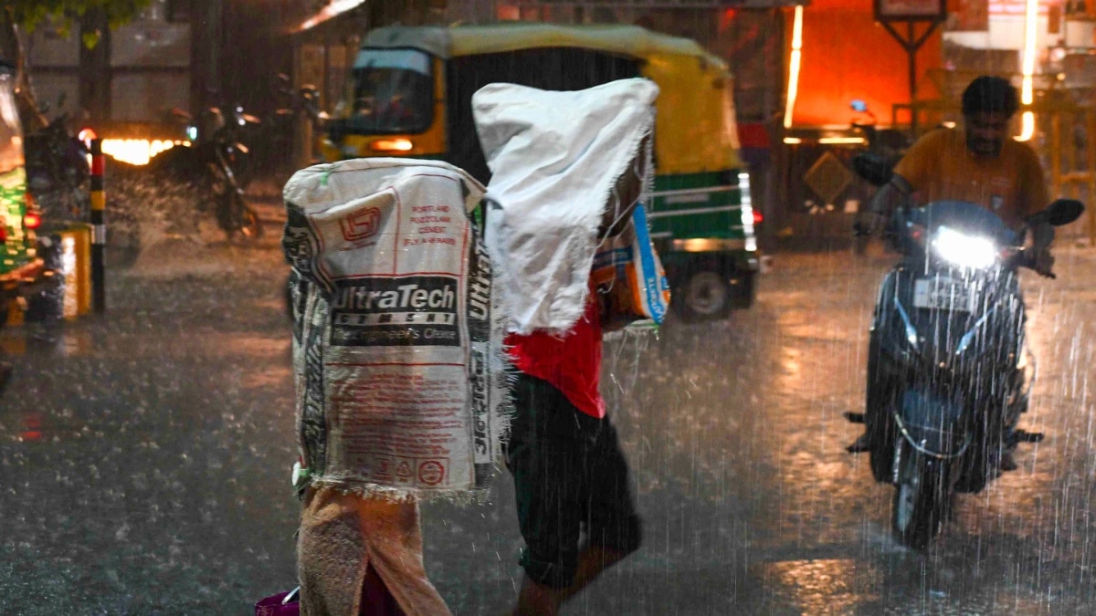 Uttar Pradesh Weather Alert: Heavy Rain Continues, IMD Forecasts Another Week Of Showers People make a feeble effort to shield themselves from the rain in Varanasi.