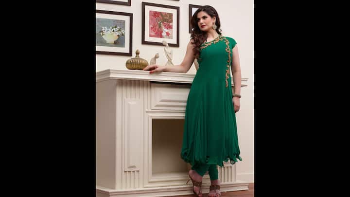 2. Zareen Khan: Zareen Khan exuded timeless elegance in her deep emerald green anarkali, an effortless choice for Hariyali Teej celebrations. The minimalist gold embroidery across the neckline added the right touch of festive flair. The sleeves and flowy hemline gave a modern twist to the traditional fit. Teamed with fitted churidar pants and statement earrings, the look balanced comfort along with glamour. This chic green suit is a stunning way to embrace the Teej traditions with Bollywood-inspired grace. (Image Source: Pinterest/sareebuzzindia)