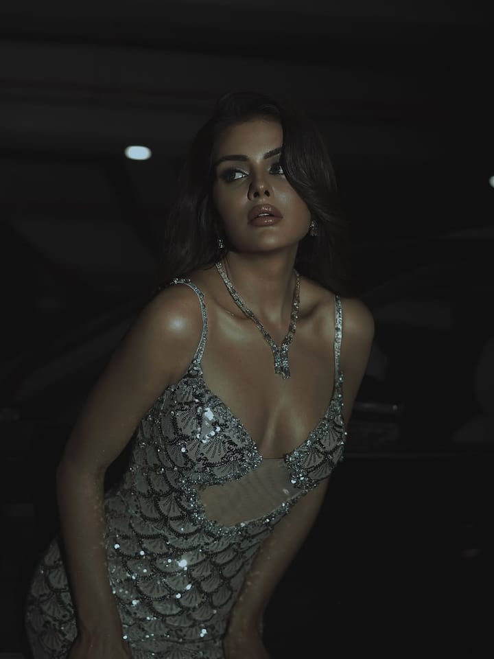 The crystal-studded spaghetti straps add subtle shimmer, enhancing the drama without overpowering the overall elegance.