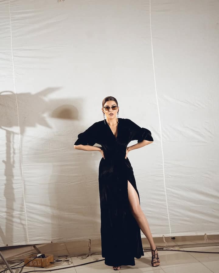 Kajal Agarwal is looking stunning in a black high slit dress. Wearing heels and black glasses, she looks very stylish.