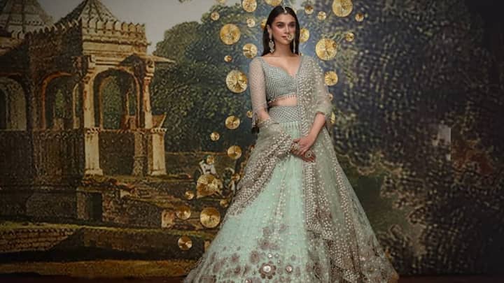 Aditi Rao looks stunning in this mint green lehenga featuring heavy embroidery. With a maang tikka, nath, and draped-down-the-shoulder earrings, her appearance spells regal elegance. (Image Source: Instagram/ aditiraohydari)