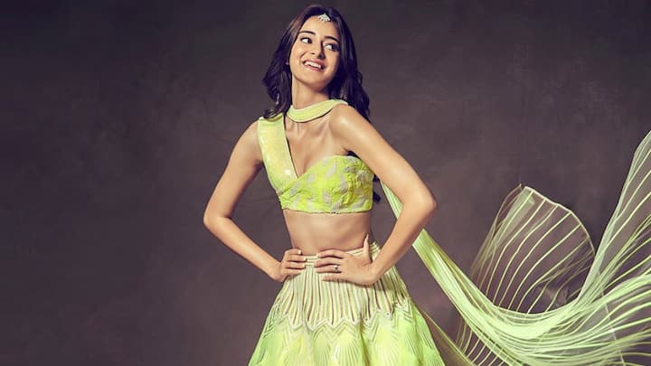 Ananya Panday stands out in this neon green monochrome lehenga with a one-shoulder blouse and translucent dupatta. A cool choice to light up Teej celebrations. (Image Source: Instagram/ amitaggarwalofficial)