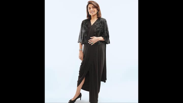 1. Black Indo-Western Look: Neetu Kapoor proved that timeless style knows no age with this elegant black ensemble. The outfit featured a beautifully draped silhouette that created a flattering effect. Paired with a cape-like blouse, the actress added a touch of sparkle and structure to the fit. The outfit radiated sophistication with a subtle shimmer, which made the actress embrace the current fashion trends while staying true to classic silhouettes. Her minimal accessories, black peep-toe heels, and a bold emerald ring enhanced the look without overpowering it. (Image Source: Instagram/@neetu54)