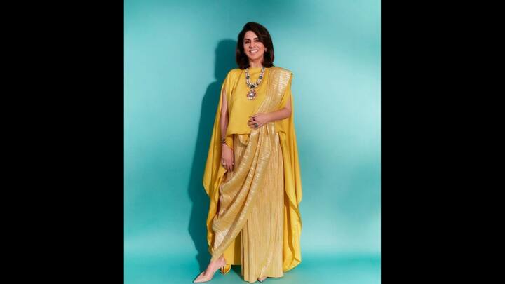 4. Modern Dhoti Saree Look: Neetu Kapoor continues to redefine elegance with a contemporary twist, and this striking yellow ensemble serves as a proof. The actress wore a cape-style saree and paired it with structured dhoti pants that effortlessly blended Indian tradition with a modern flair. The look featured a sleeveless blouse with flowy cape sleeves that draped gracefully down her arms. The pleated dhoti bottoms added texture and a luxurious sheen while the saree-style drape gave a perfectly coordinated silhouette. Neetu amped up the glam with layered polki gemstone necklaces, a bold cocktail ring, and a chic bracelet, enhancing the outfit's vibrancy. (Image Source: Pinterest/HelloMoonlight_)