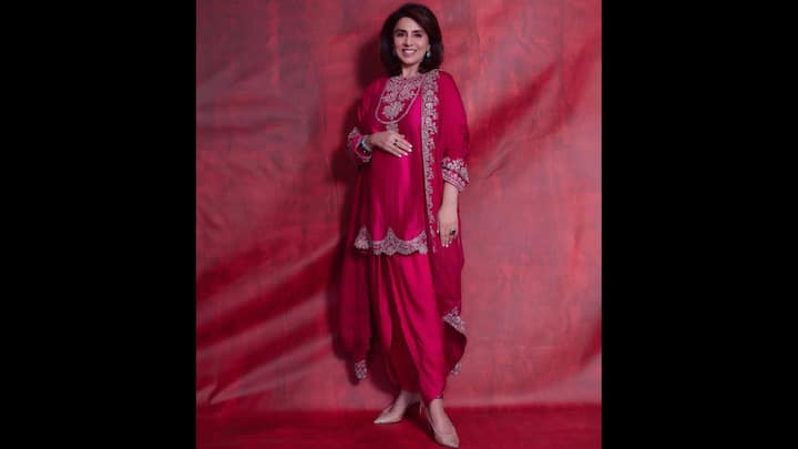 3. Hot Pink Embroidered Kurta Set: Neetu Kapoor wore a striking hot pink ensemble that effortlessly blended regal and radiance. Dresses in a rich silk kurta with intricate zari embroidery along the neckline, hem, and dupatta, the actress served a classic look. The outfit was paired with dhoti-style bottoms that added a playful yet elegant twist to the traditional wear. The sheer dupatta, adorned with matching embroidery gave a rich aura, while completing the coordinated look. Neetu accessorised the bold look with turquoise earrings and shimmery nude heels. (Image Source: Instagram/@neetu54)