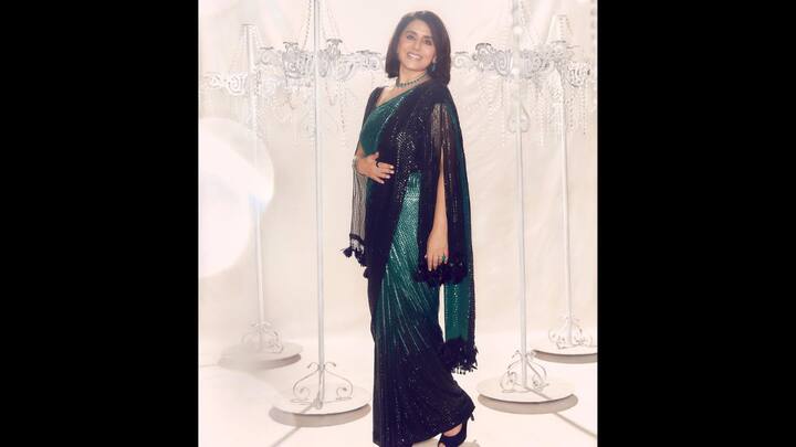 7. Black And Emerald Sequin Saree: Draped in a show-stopping emerald green and black sequin saree, Neetu Kapoor looked radiant and runway-ready. The saree featured a shimmering emerald green base with a pleated silhouette that was effortlessly complemented by a glossy sequin pallu. The outfit perfectly balanced old-school charm with new-age flair. The look was enhanced by a textured blouse featuring fringe cape-style sleeve, that added a touch of evening drama. The actress accessorised her outfit with a matching emerald jewellery pieces. (Image Source: Instagram/@neetu54)