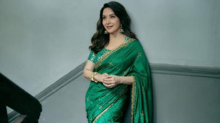 Subtle Golden Accents: Wearing this gorgeous green saree with fine golden borders, Madhuri looked like subdued elegance. Combined with a green blouse with soft golden patterns, it's an ageless choice for daytime celebrations. (Image Source: Instagram/ madhuridixitnene)