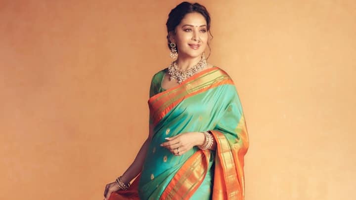 Teal And Orange Silk Fusion: This stunning teal and orange embroidered silk saree provided a splash of contrast to Madhuri's conventional outfit. The rich concoction is a perfect embodiment of the fun and colours of Hariyali Teej.  (Image Source: Instagram/ madhuridixitnene)