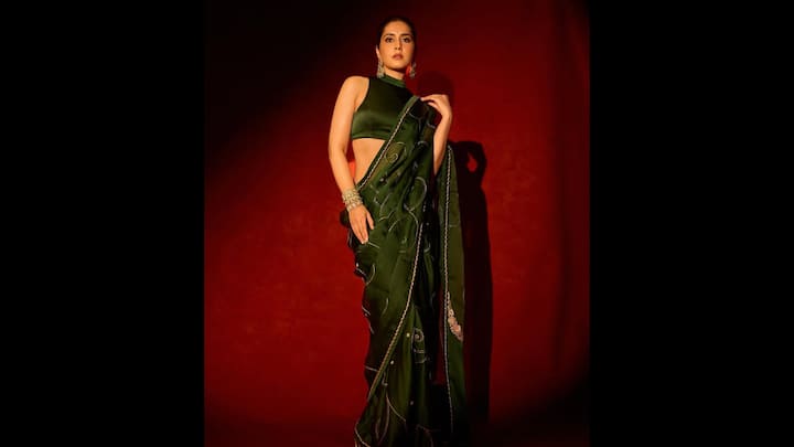 2. Raashii Khanna: Raashii Khanna lit up the style scene in a rich emerald green saree. She paired her traditional look with a sleeveless high-neck blouse that sculpted her silhouette. The saree, adorned with subtle thread embroidery and delicate shimmer accents, looked regal and added a festive allure. The actress wore statement jhumkas and stacked gold kadas which sealed her Hariyali Teej-ready look, making it both contemporary and ethnic. (Image Source: Instagram/@raashiikhanna)