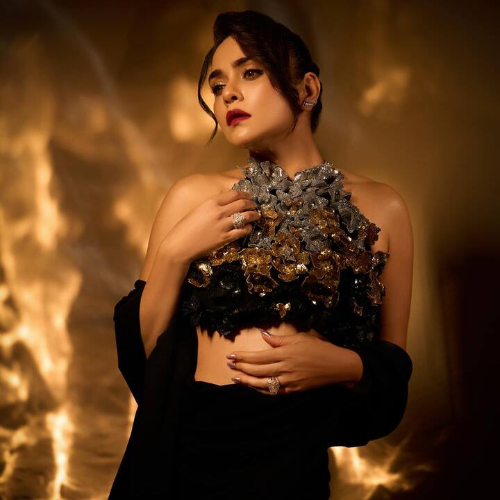 तिच्या ड्रेसमधील मेटॅलिक थ्रीडी फ्लोरल डिझाइन गोल्ड, सिल्व्हर आणि ब्लॅकच्या कॉम्बिनेशनमध्ये अतिशय इनोवेटिव्ह आणि हाई-फॅशन वाटतो.