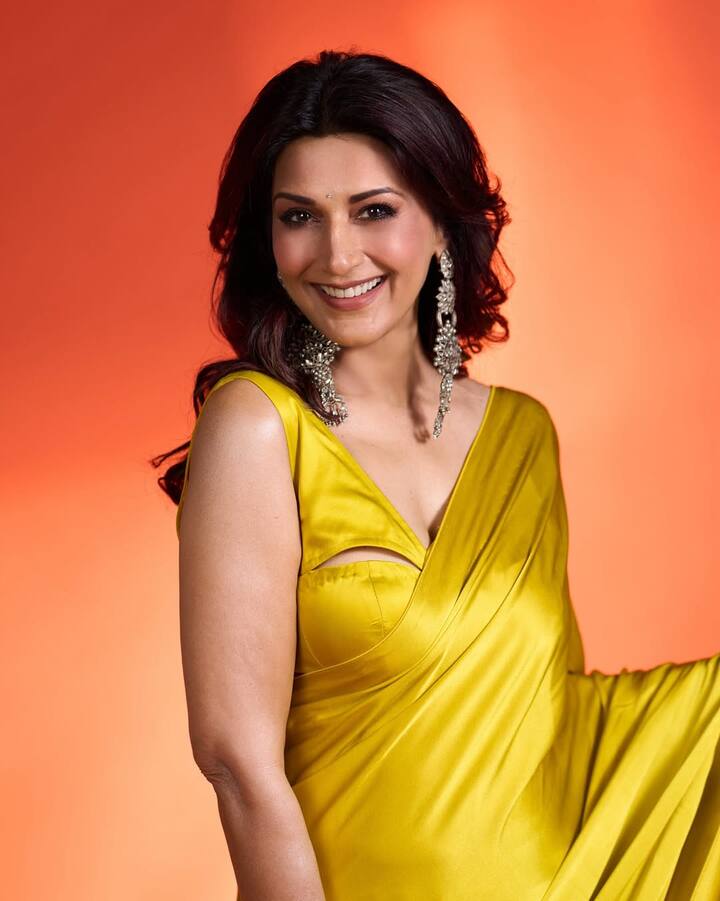 A tiny bindi, her soft smokey eye and glossy nude lip complete the refined glam.