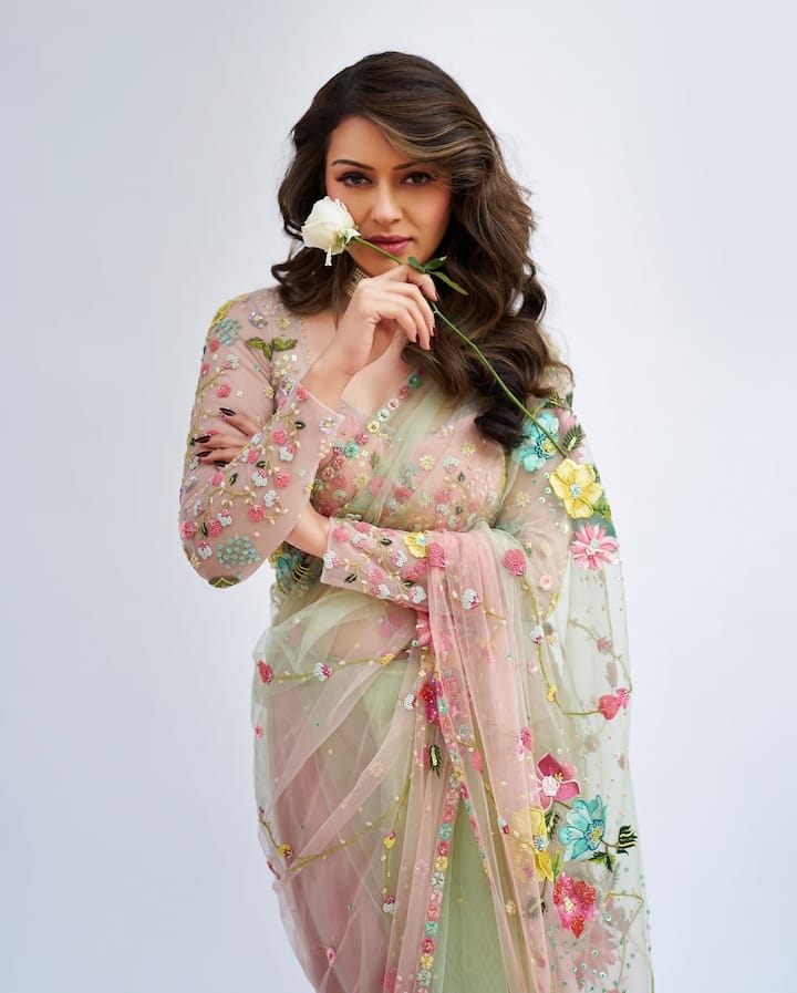 This saree of Hansika with a 3D flower embroidered on the light net fabric is quite trendy with being elegant. Ladies can take an idea from this style for their outfits.