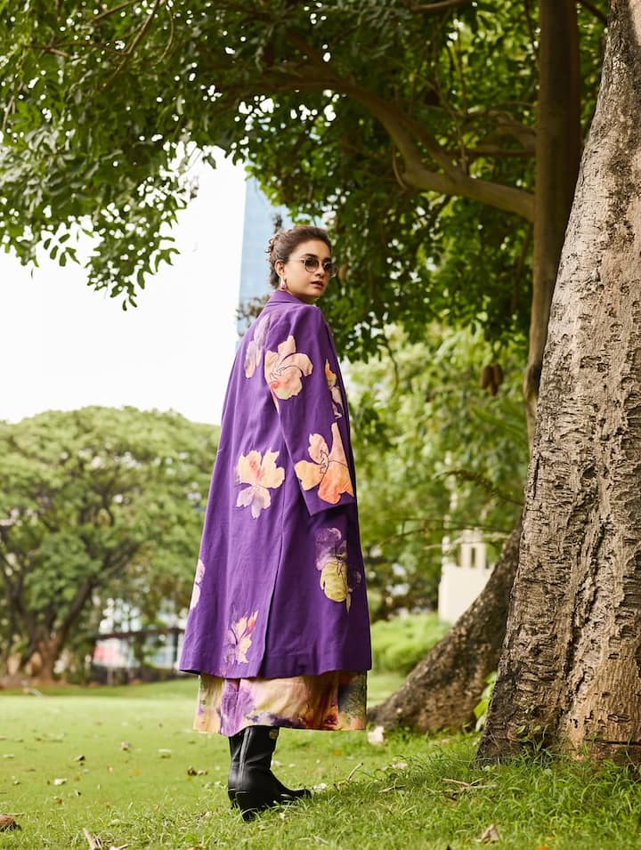 The actress can be seen wearing a rich purple oversized jacket adorned with hand-painted floral motifs.