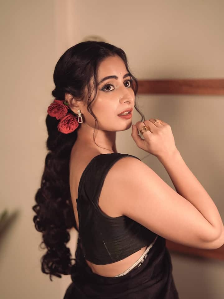 A tiny black bindi and flicked eyeliner finish the look with retro finesse.