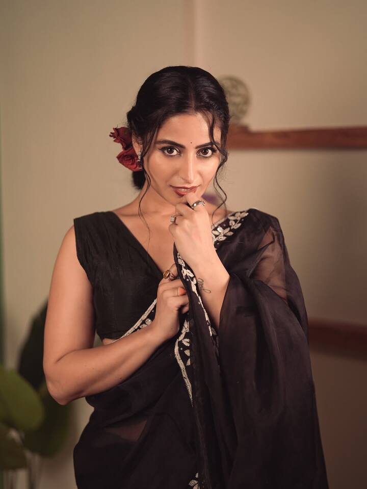 Her dewy makeup, warm-toned blush, and rust-hued lips create a glowing canvas.