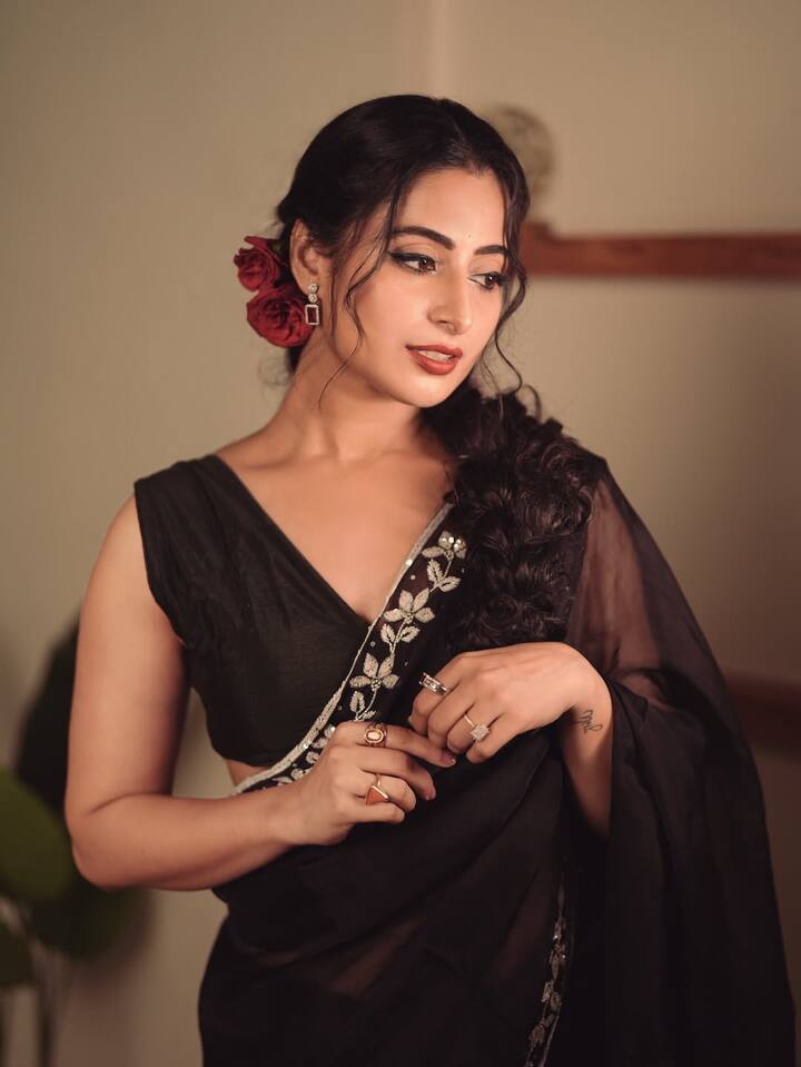 The minimal jewellery, statement earrings and stacked rings keep the focus on her expressive eyes and vintage vibe.