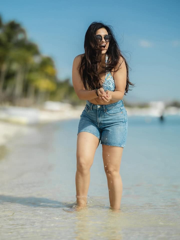 High-West denim shorts with blue printed bikini top. This look shows Shweta's cool and confident side. Glasses and hair flow have put the look in perfect beach mode.