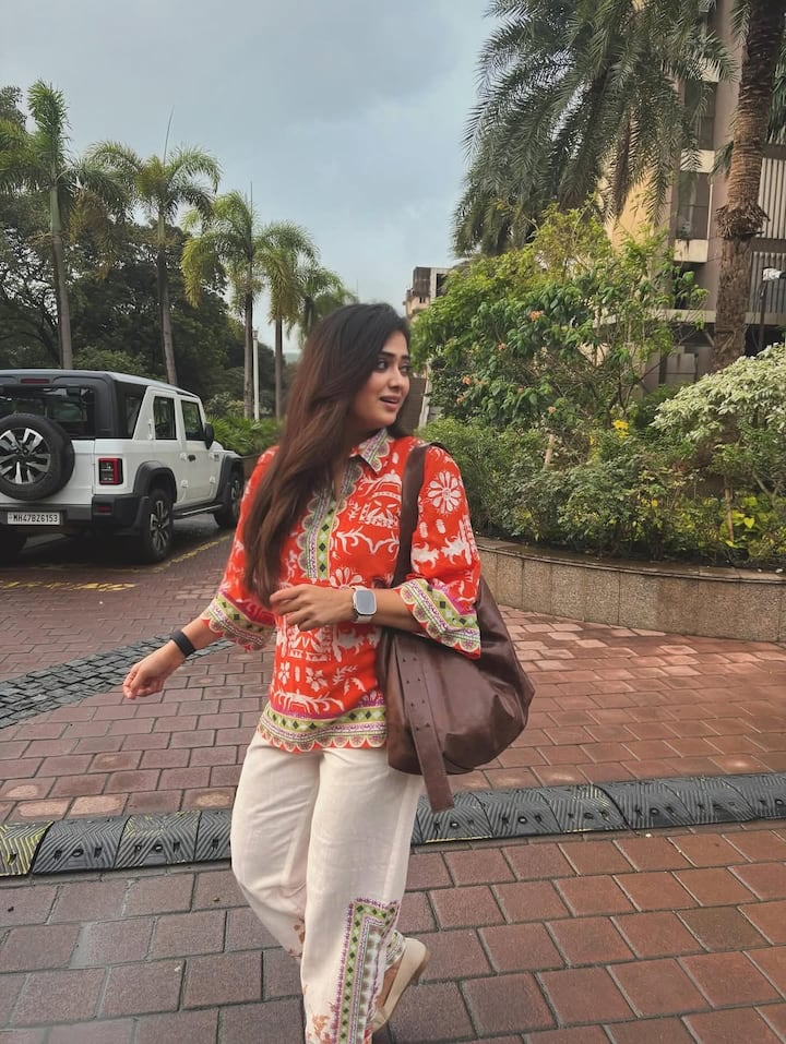 Shweta has completed this look with cream white trousers with Orange Ethnic Printed Kurti. This look is complicated desi and comfortable. Brown Sling Bag and Apple Watch made the look simple but stylish.