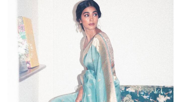 She went for the old-world charm with this sky-blue Banarasi saree in floral gold zari motifs. With some traditional jhumkas and a utility-cum-soft dewy makeup look on her face, the subtle ensemble spoke of grace and simple festive elegance. (Image Source: Instagram/ hegdepooja)