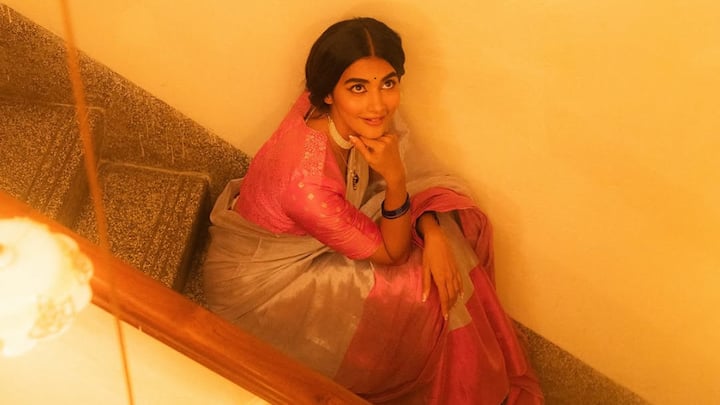 Pooja Hegde looked incredibly graceful in this off-white saree with light-pink borders. The outfit called for a matching pink blouse adorned with gold prints. This very classic and festive ensemble was accentuated with a layered pearl necklace and a braided hairstyle. (Image Source: Instagram/ hegdepooja)