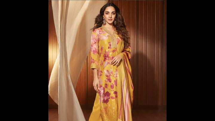1. Yellow Floral Kurta Set: This yellow floral kurta set worn by Kiara Advani is perfect if you’re looking for an outfit that balances elegance with vibrance. The rich mustard-yellow base adorned with soft pink floral prints instantly uplifted the look. It features delicate embroidery around the neckline that added a touch of traditional grace. The actress paired her look with statement chandbalis, radiating warmth and a contemporary style. (Image Source: Twitter/@BreezeDotIn)