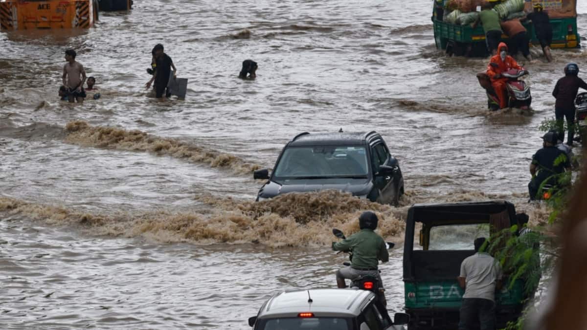 A car struggles on a flooded Gurugram street.
