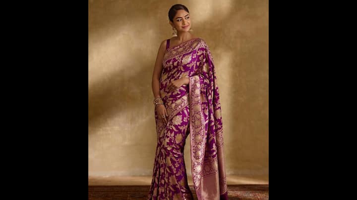 5. Royal Purple Banarasi Silk Saree: Mrunal Thakur channeled regal charm in a traditional Banarasi silk saree for Raksha Bandhan 2025. The rich royal purple adorned with intricate golden zari weaving, featured floral and paisley motifs. The luxurious texture and vibrant hue made this saree a timeless festive classic. Mrunal complemented the heritage weave with jhumkas, stacked bangles, and a neat bun. With subtle makeup, the actress allowed the saree’s opulence to shine. (Image Source: Pinterest/mostlyfavs)
