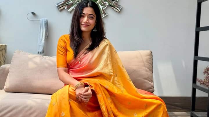 Rashmika's yellow and orange Banarasi saree sparkles with festive vibes. The traditional patterns and gold embroidery make it a timeless choice for Raksha Bandhan celebrations. (Image Source: Instagram/ rashmika_mandanna)