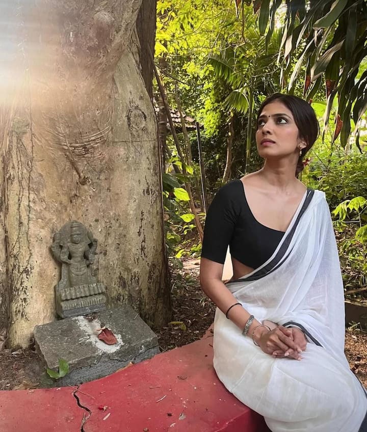 A Vision in Monochrome: Malavika radiated timeless charm in a white cotton saree with a bold black border, paired with a half-sleeved deep-neck black blouse and a simple black bindi. Minimalism at its finest.