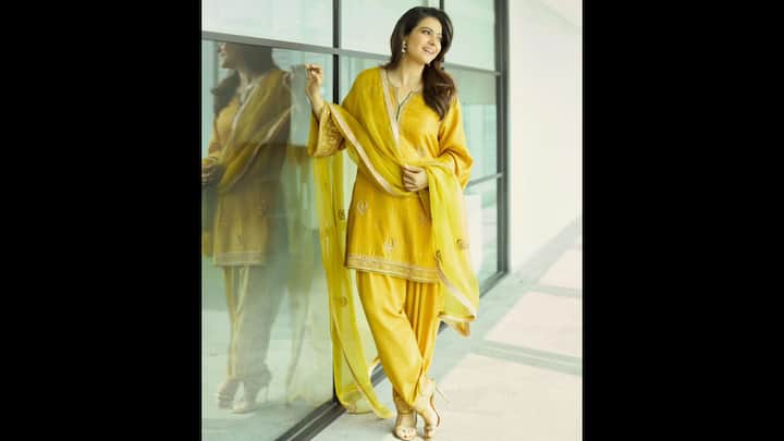 1. Radiant Mustard Yellow Salwar Suit: This fit worn by Kajol will definitely bring sunshine to the celebrations. It perfectly blends tradition and modern charm. This festive outfit featured a straight-cut kurta with subtle zari embroidery, paired beautifully with a classic Patiala salwar. The actress wore an elegant dupatta that was adorned with delicate motifs. The look was completed with strappy golden heels and statement earrings, adding a graceful touch to the traditional ensemble. Kajol’s yellow suit is a perfect Raksha Bandhan outfit idea for women who want to keep it elegant yet festive. The warm hue not only radiates warmth but also complements the joyous spirit of the celebration. (Image Source: Instagram/@kajol)