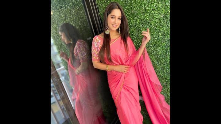 8. Vibrant Coral Saree: Dipika Kakar brings festive charm to life in this vibrant coral pink saree paired with a delicately embroidered floral blouse. The understated golden border adds just the right touch of elegance, while the rich hue is both youthful and festive. This saree is ideal for a Raksha Bandhan celebration at home or a family get-together. What truly elevates the ensemble is her choice of long silver statement earrings and a traditional kada bracelet, adding ethnic finesse without overwhelming the look. Dipika proves that sarees never go out of style, especially when styled with grace.  (Image Source: Instagram/@ms.dipika)