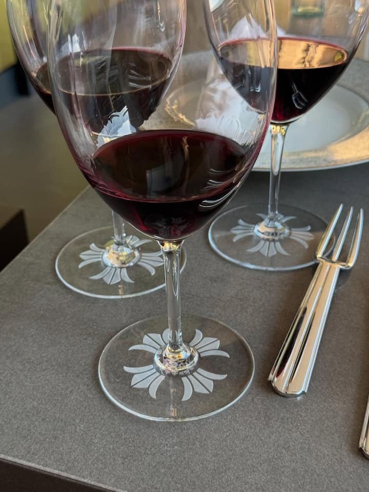 One photo featured three crystal wine glasses partially filled with red wine.