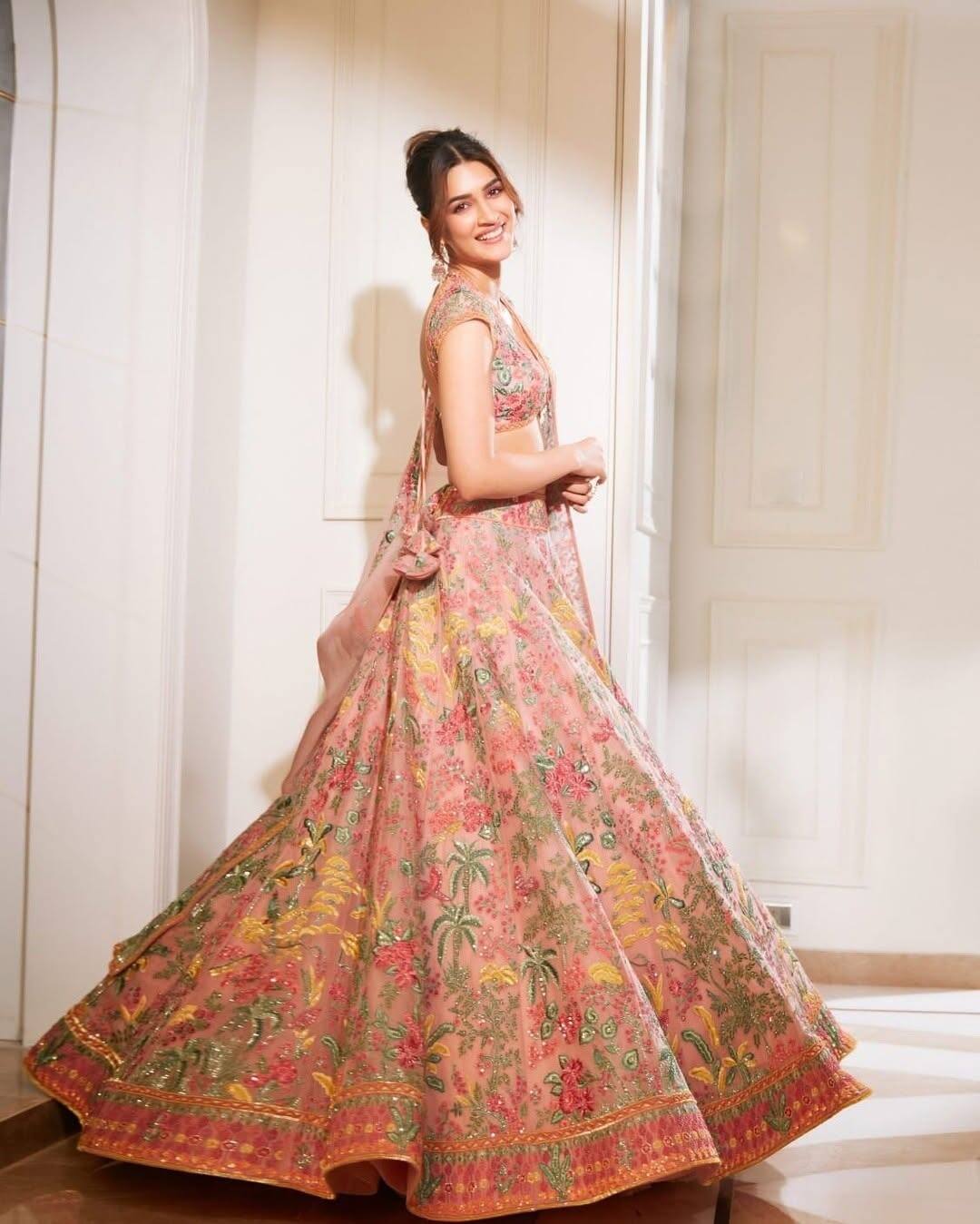 Like Kriti Sanon, you can style the pastel color lehenga of your Radha Rani Look. The actress has completed her look with statement earrings and bun hairstyle.