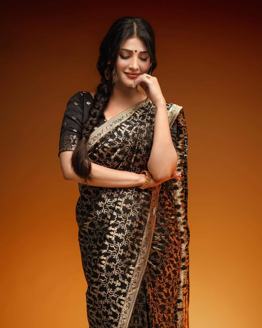 What to say on this look of Shruti. She is wearing a black gold color saree, whose pallu is a hindrance to the pleat to make her elegant. Also, he has kept his hair in a massey peak, wearing a big black dot, earrings and a golden tough. This look is quite graceful and cute.