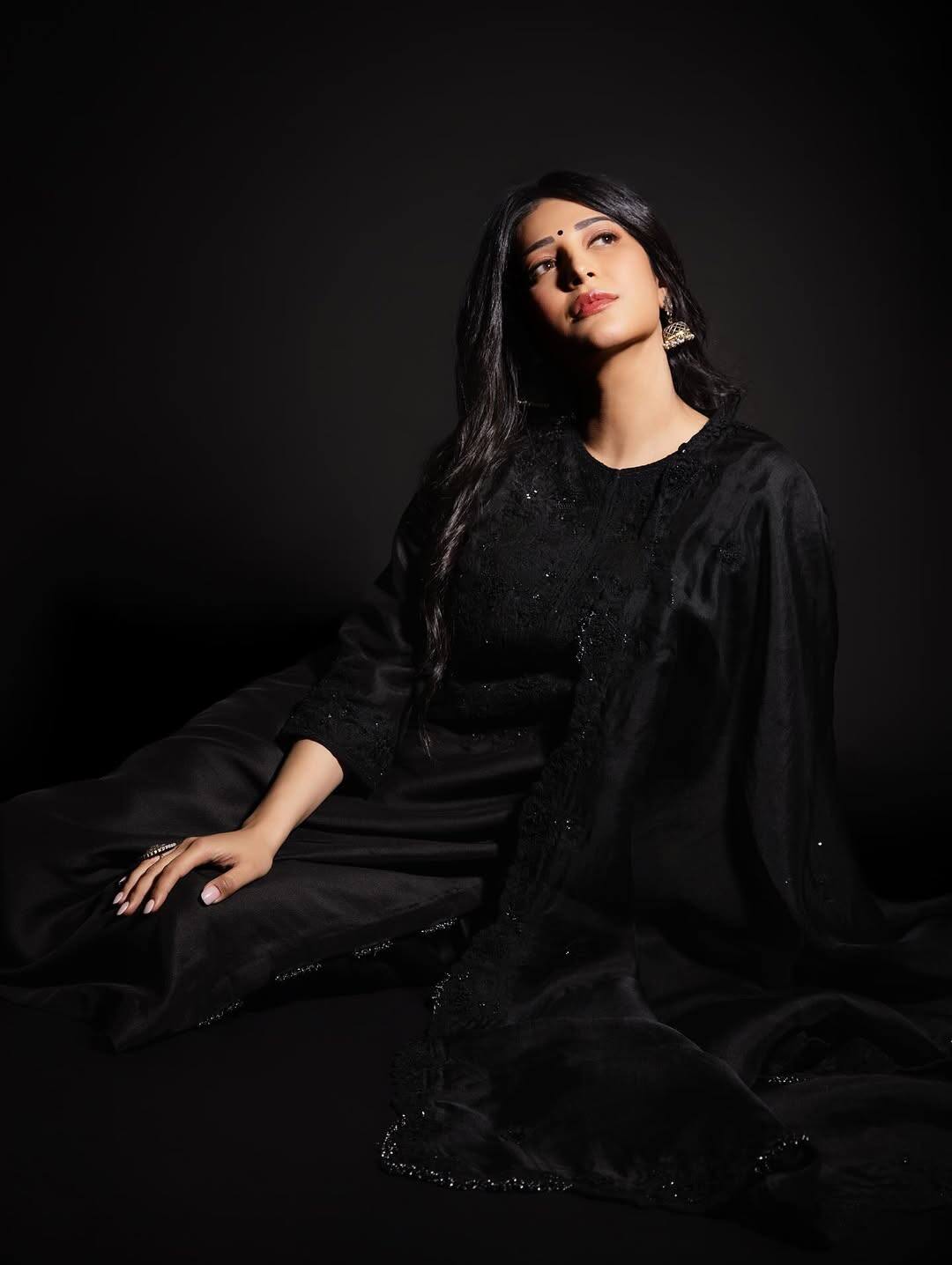 Looking at Shruti Haasan's Instagram, it is obvious that the actress's favorite color is black and red. In this first look, she is wearing a beautiful three piece suit of black color, she has done curls to complement this look and also completed the look with earrings and black bindi.