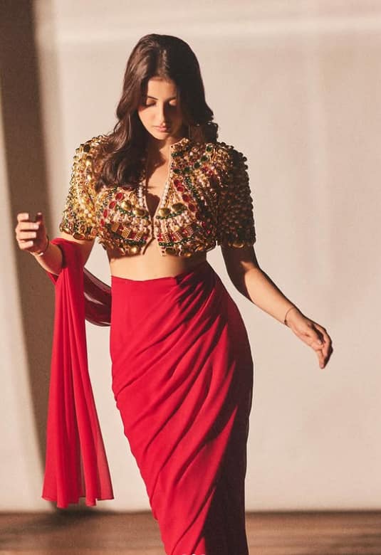 Navya looks no less than a Bollywood actress in this Indo Western dress. She has completed red sari and heavy blouse with light makeup and middle parted hairstyles.
