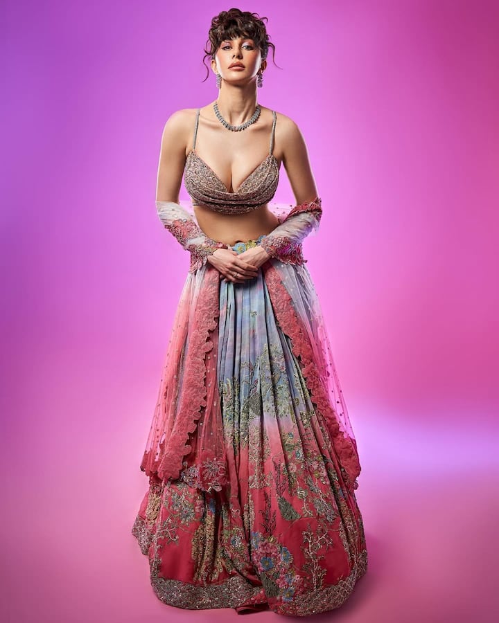 Modern romance- This multi-colored lehenga, made up of a combination of pink, blue, silver and gold, reflects the experimental style of Georgia. Detacched sleeves and modern draping make it new and trendy, especially for modern braids. This look beautifully combines traditional workmanship with modern design sense.