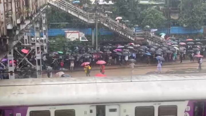 कळव्यातील रेल्वे प्रवासी जीव धोक्यात टाकून भर पावसात रेल्वे ट्रॅकवरून ट्रेन पकडण्याचा प्रयत्न करत आहेत