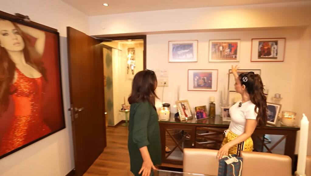 There is also a big dining area in the house. In this too, white chairs have been installed along the table. Also, there are photo frames of actresses on the walls.