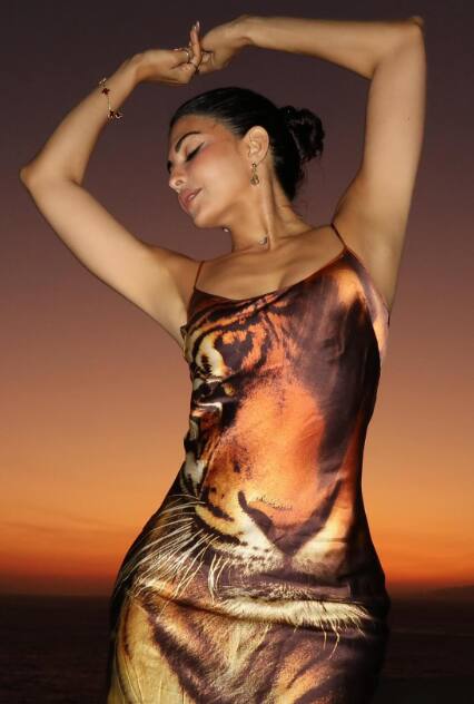 The actress looks quite stylish in a brown colored long tiger print bodycon dress.