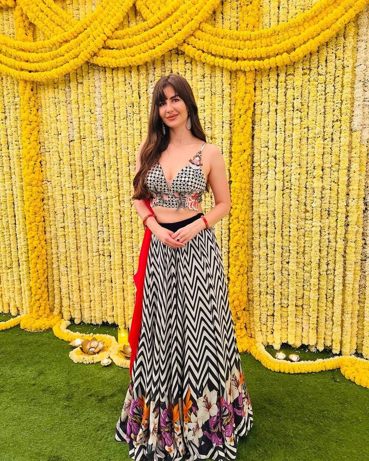 Boho Shik Vibes- In this lehenga with black and white geometric prints, Georgia gives a fresh and fun twist to the traditional look. This contemporary pattern and comfortable silhouette with bright marigold yellow background prove that lehenga can be stylish as well as comfortable. This look reflects the playful but elegant soul of modern Indian fashion beautifully.