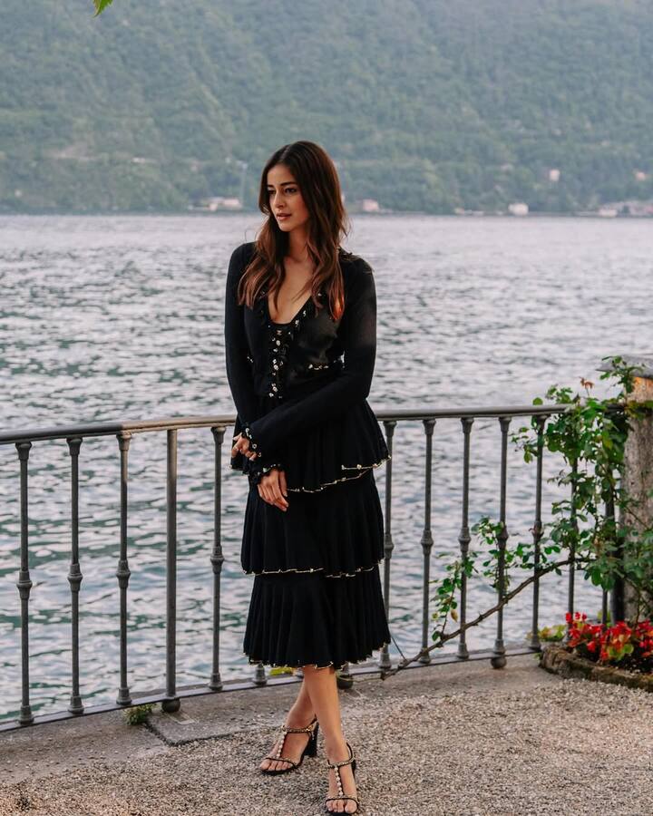 Ananya is wearing a black co-ord with lace-up detailing and pleated skirts in this look. They have styled with stripped heels, soft waves and nude glams together. This lakeside look looks quite elegant.