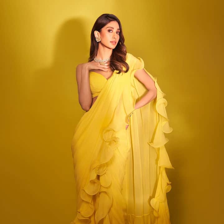 Paloma is looking very stunning in Yellow color ruffle style saree. He has added beauty to his look with white and golden jewelery.