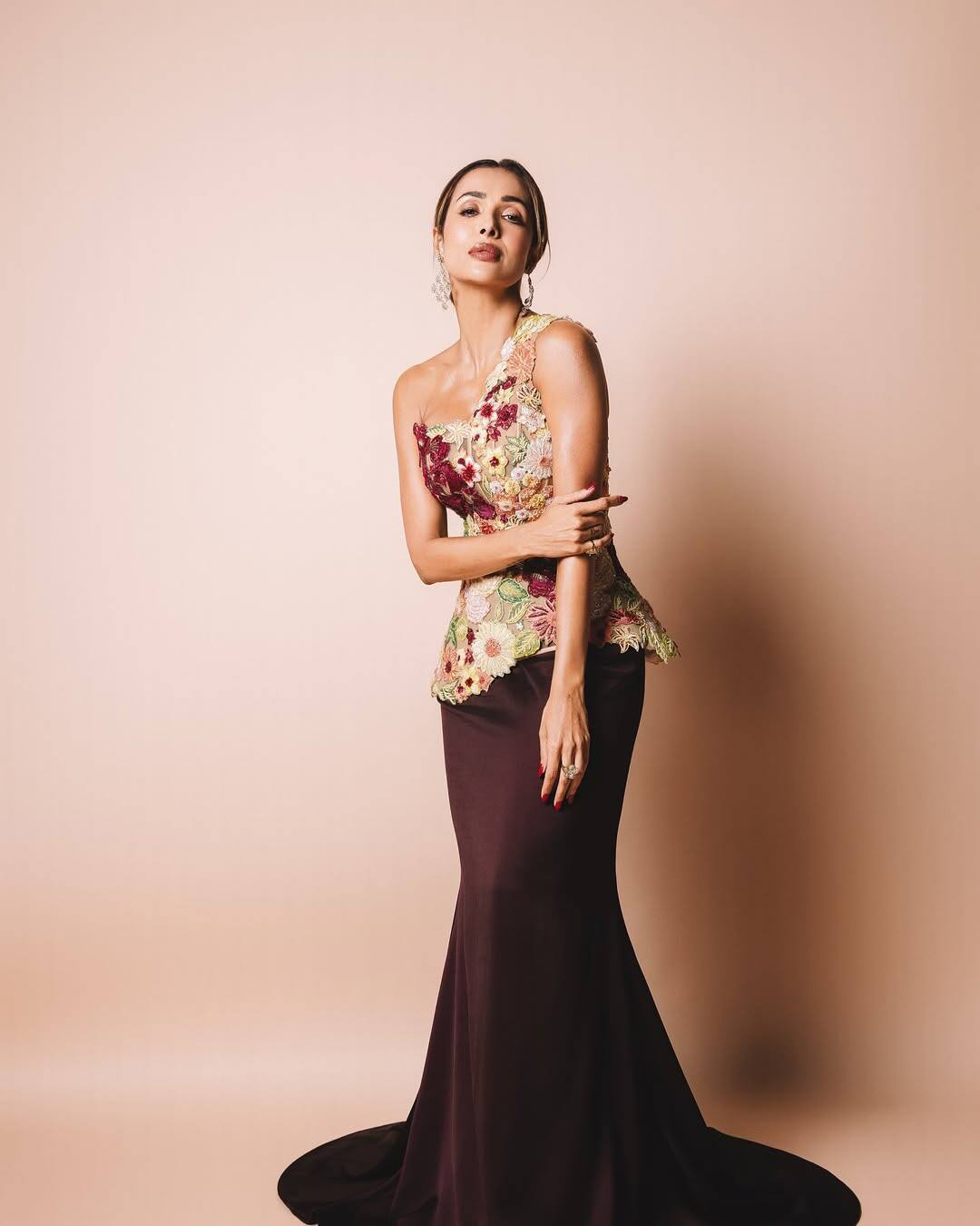 Malaika Arora fascinates everyone in glamorous and contemporary style. One shoulder, wine -colored trousers with floral embroidered corset tops. His look is minimalist styling. He has completed this look with diamond statement earrings and sleek hair.