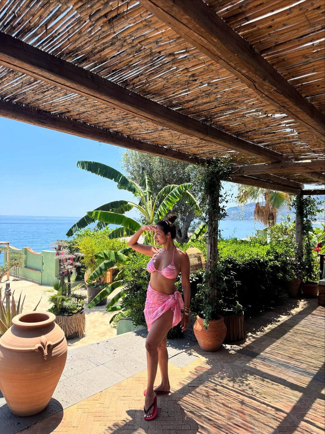 In this look, Malaika has kept a style of vacation vibe. She is wearing a pink bikini top and matching skirt. With flat slippers and minimal accessories, he has kept this look very casual.