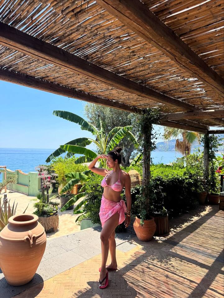 In this look, Malaika has kept a style of vacation vibe. She is wearing a pink bikini top and matching skirt. With flat slippers and minimal accessories, he has kept this look very casual.