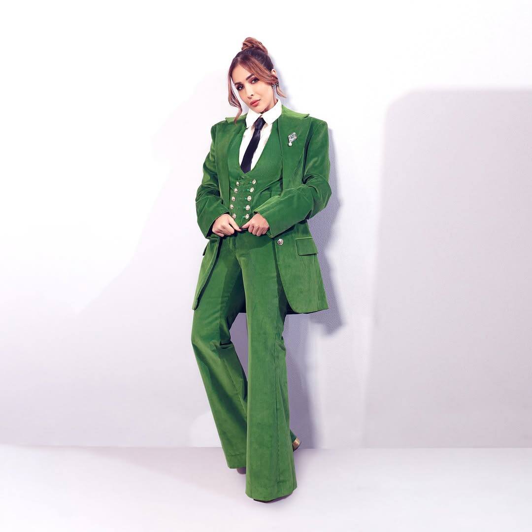 In this look, Malaika is wearing a very powerful and stylish green pantsuit. This suit of velvet fabric is giving them a royal and classy look. It is also giving a fashionable look with his outfit formal with black tie and white shirt.