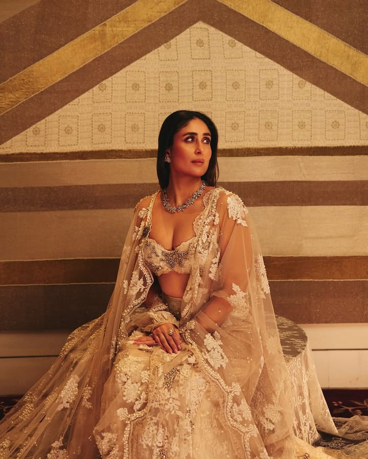 In this look, Kareena looks very royal and elegant. He is wearing a nude-tond, heavy embroidered lehenga, which has white threadwork and sequin detailing. This look has a net dupatta and deepne blouse. For jewelery, he has worn stone studied necklace, matching earrings and statement rings.